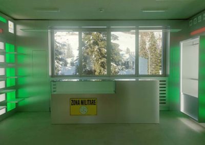 Interno elegante dello shop Zona Militare Key Comunicazione con luci LED verdi e vista invernale a Corvara